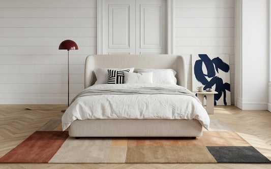 Beige upholstered bed placed correctly for ideal head direction while sleeping.