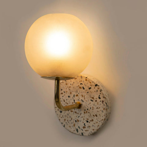 Eros White Wall Lamp with Terrazzo base, Gold-finished Mild Steel, and Frosted Glass shade.  This lamp is available online in India.