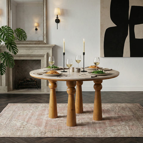 Round wooden dining table with candles in a modern neutral dining room.
