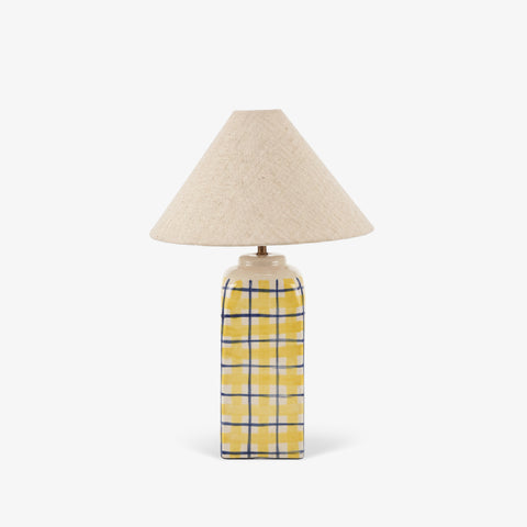 Studio shot of the striped ceramic table lamp with a tan shade against a white background.