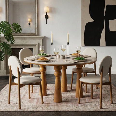 Round wooden dining table with upholstered chairs in an elegant modern dining space.