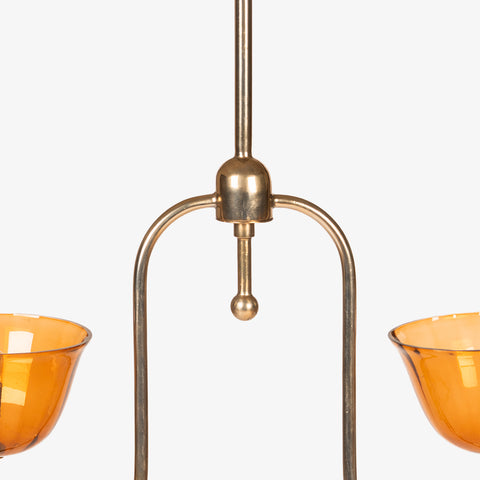 Close-up of the upper brass frame and hanging mechanism of the pendant light.