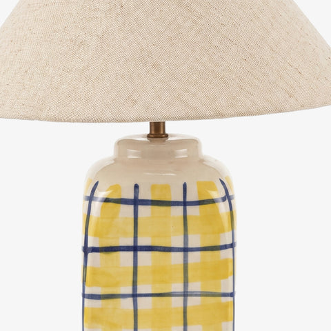 Close-up of the striped table lamp styled next to books on a wooden console.