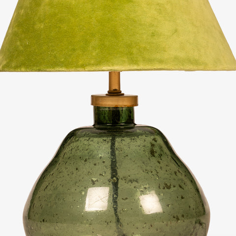 Close-up detail of the green fabric lampshade and brass neck hardware.