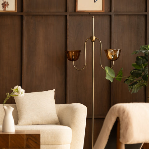 Brass floor lamp between two modern lounge chairs.