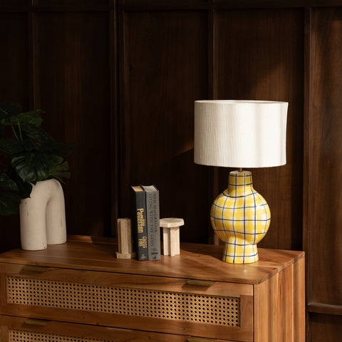 Close-up of the yellow checkered table lamp on a wooden side table.