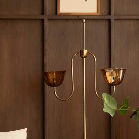 Upper half of the brass lamp against wood paneling.