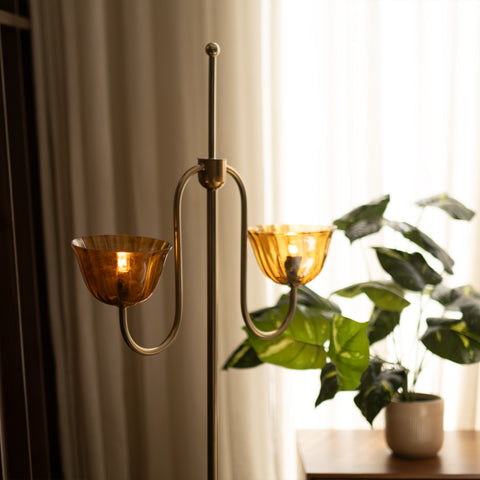 Lit amber glass lamp shades near a houseplant.