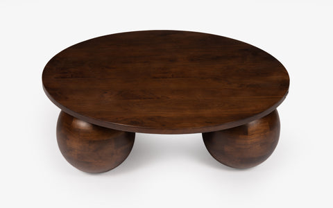 Wooden coffee table with spherical bases on a white background