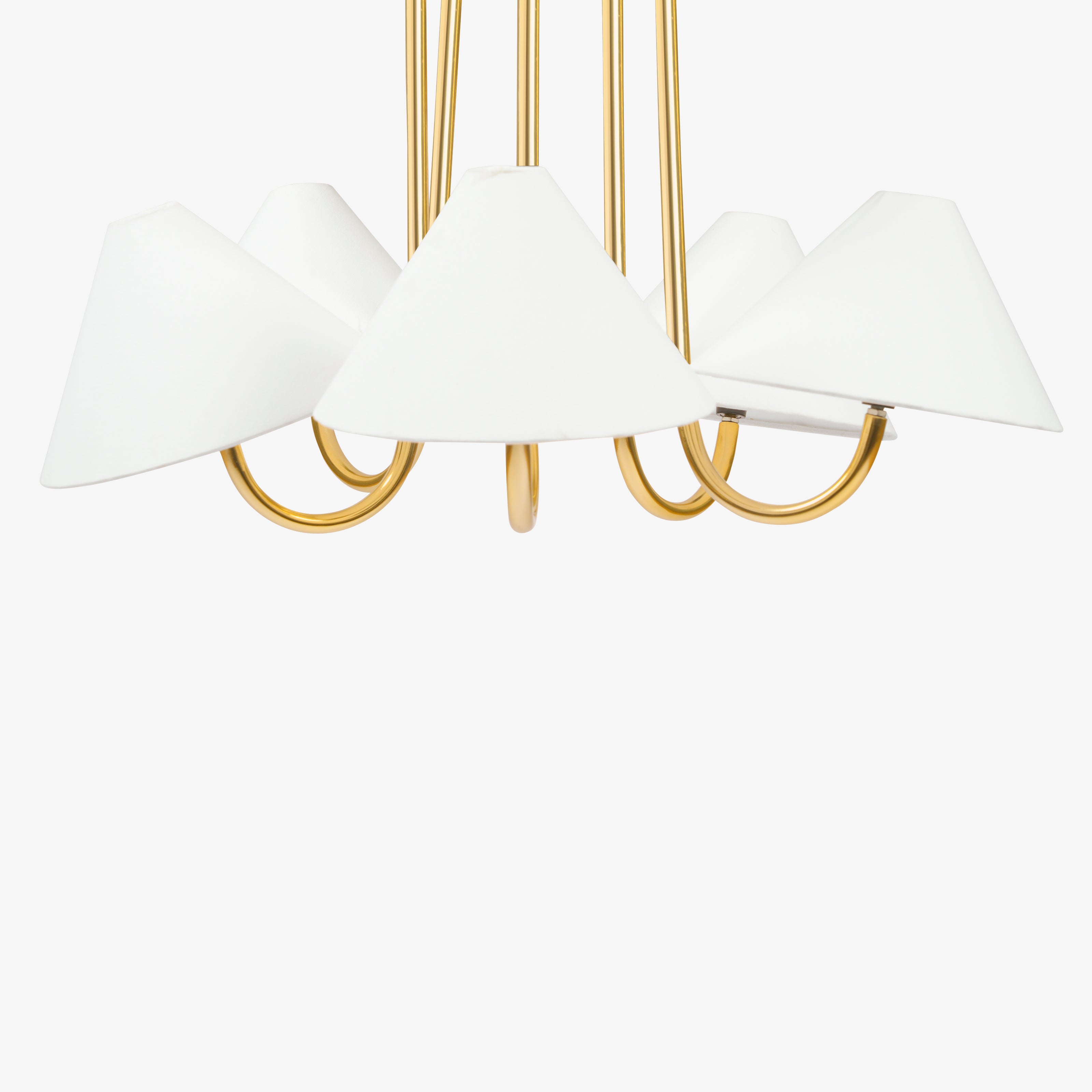 Brass chandelier lower arm detail with white fabric lamp shades.