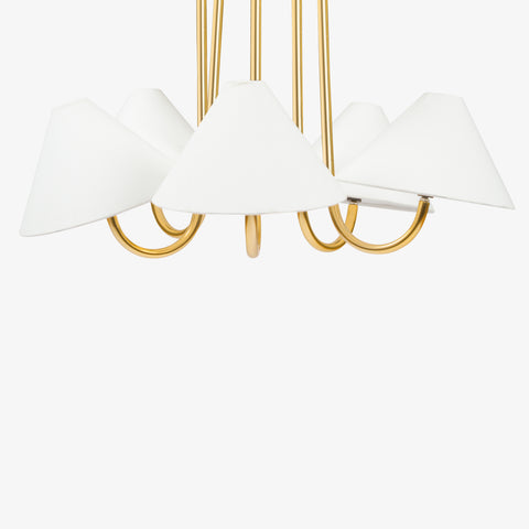 Brass chandelier lower arm detail with white fabric lamp shades.