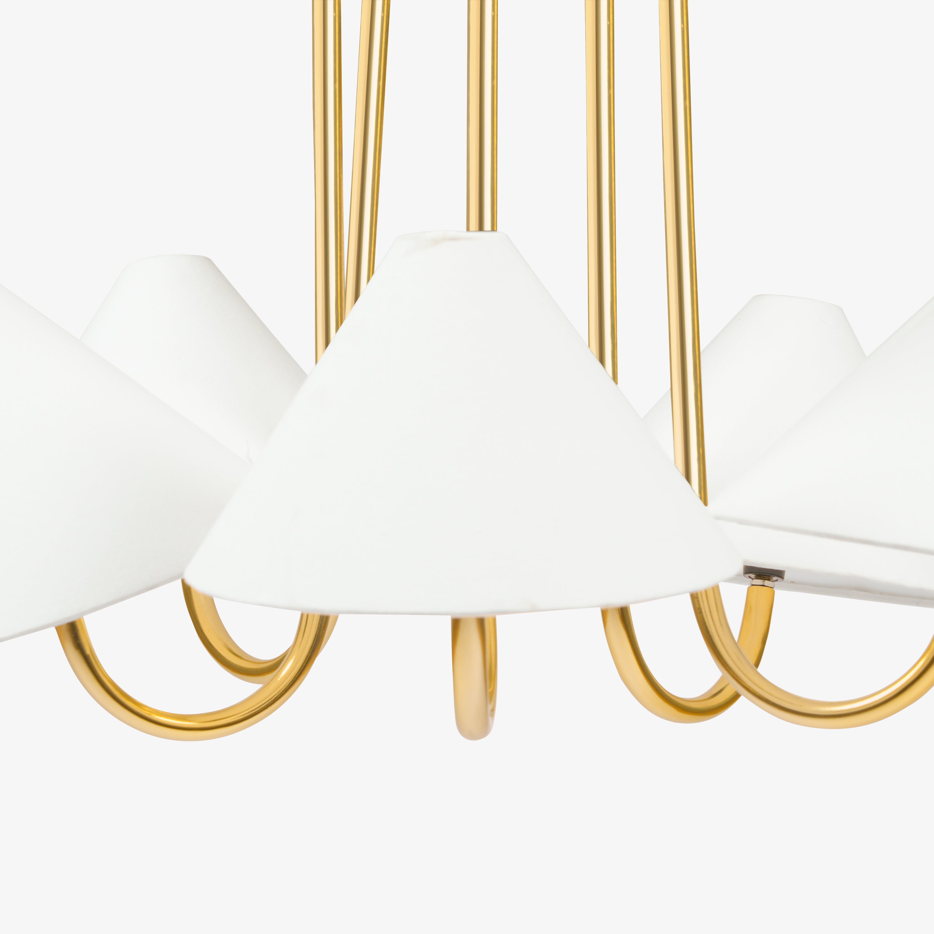 White linen lampshade detail on brass chandelier lighting.