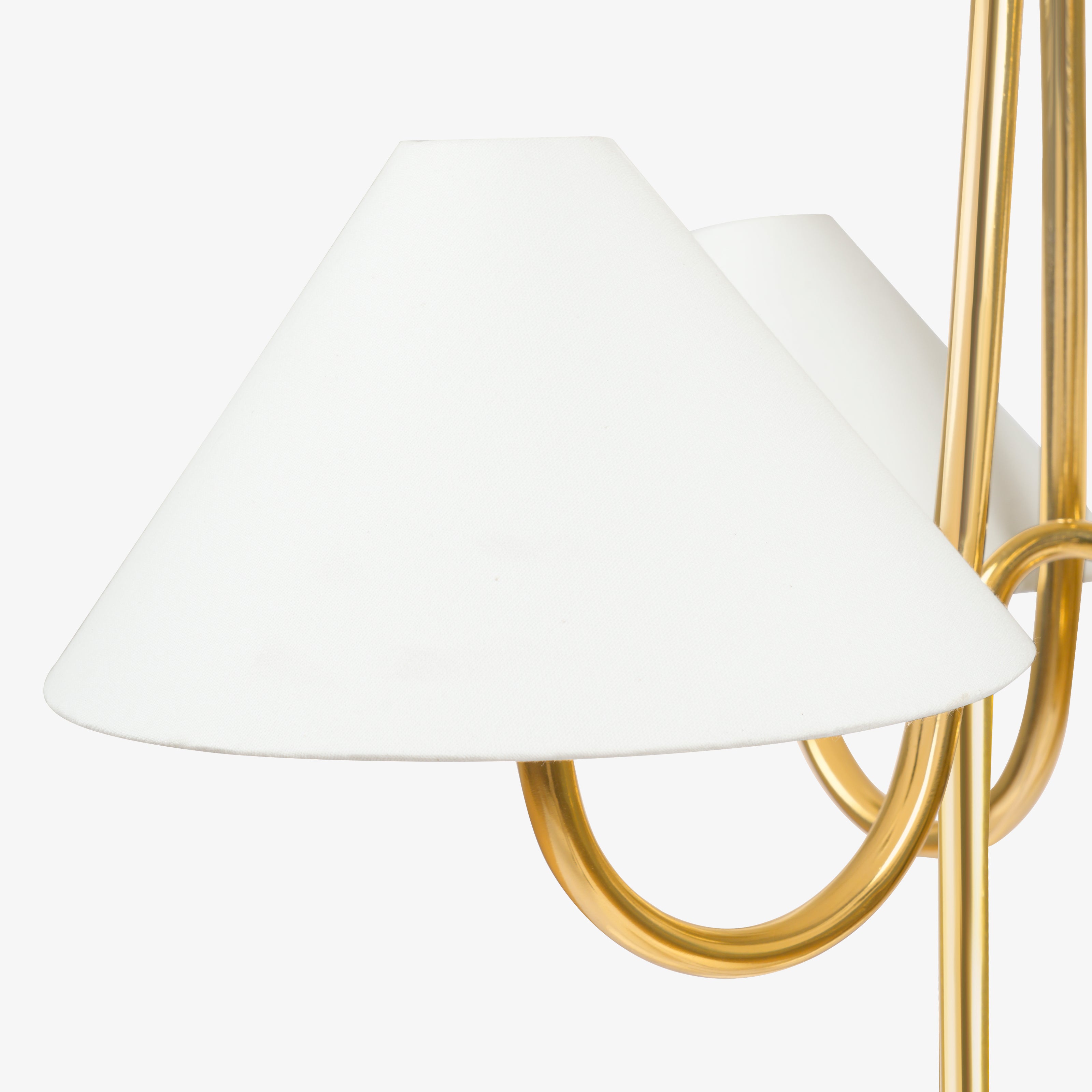 Conical white lampshade with brass arm, modern chandelier detail.