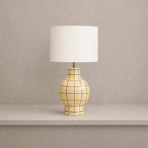Yellow plaid ceramic table lamp with a white drum shade.