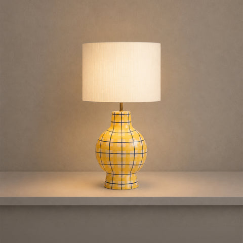 Illuminated yellow checkered table lamp glowing in a dark room.