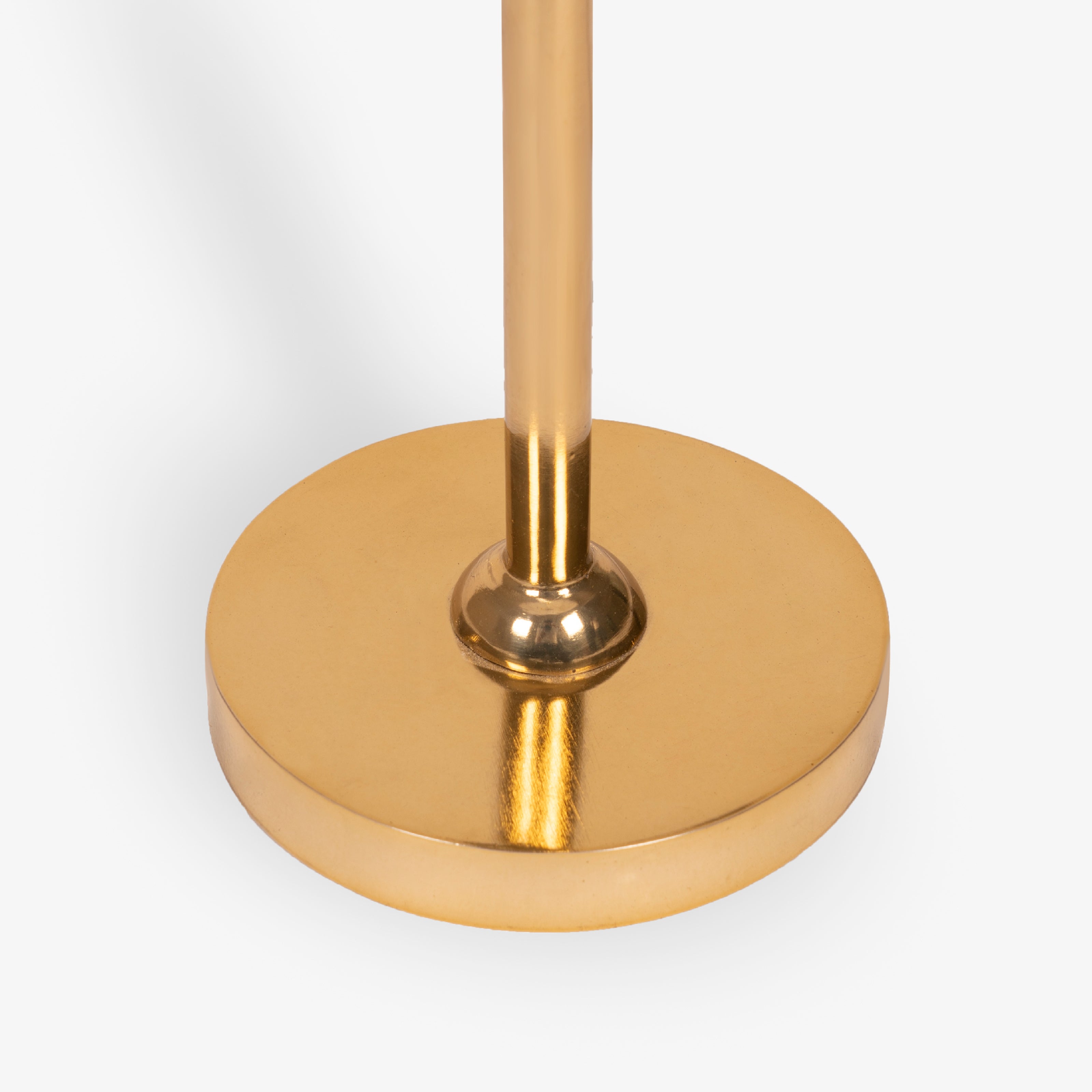 Round brass metal base of floor lamp with polished finish and slim vertical stem.