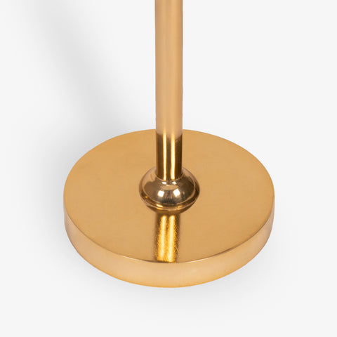 Round brass metal base of floor lamp with polished finish and slim vertical stem.