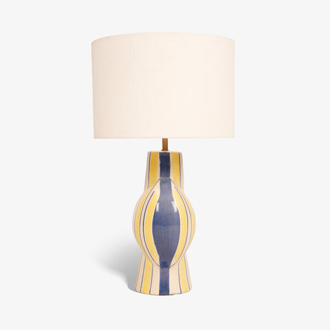 Studio shot of the yellow and blue striped ceramic table lamp on a white background.
