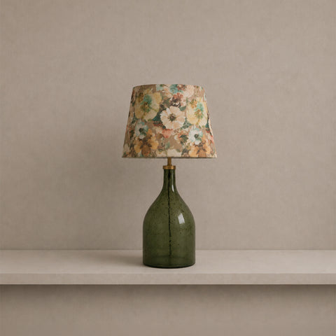 glass bottle lamp casting a warm glow on a shelf.