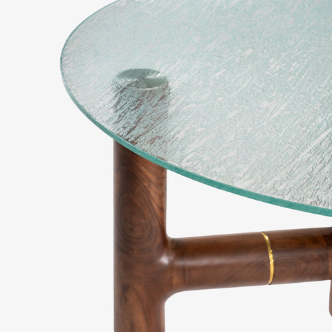 A close-up detail of the coffee table’s edge, highlighting the thick, textured green glass.