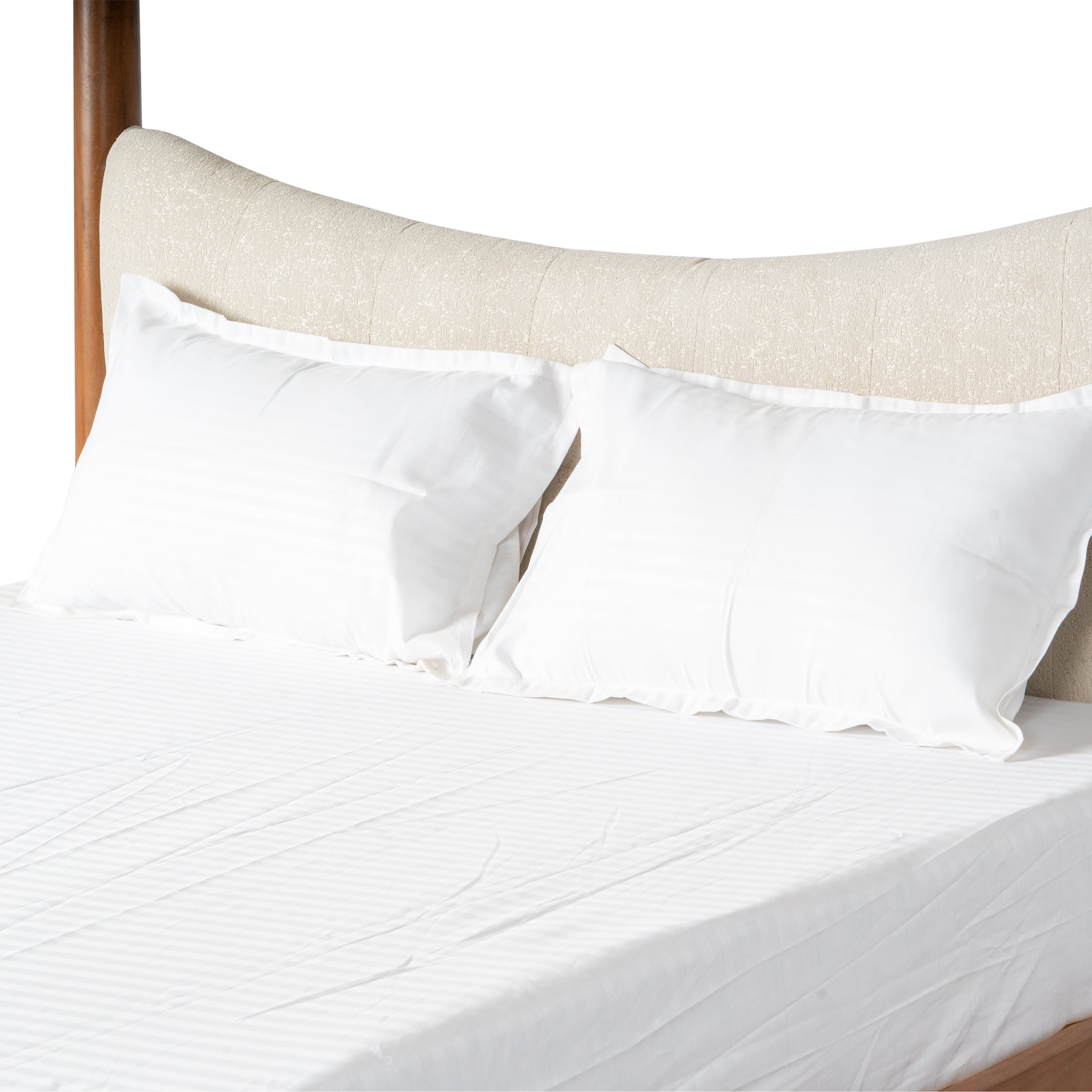 Close-up of white pillows and mattress on a wooden bed.