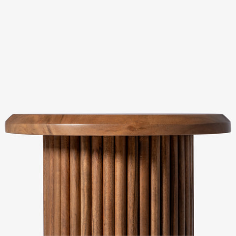 Close-up of the wooden tabletop and fluted base design.