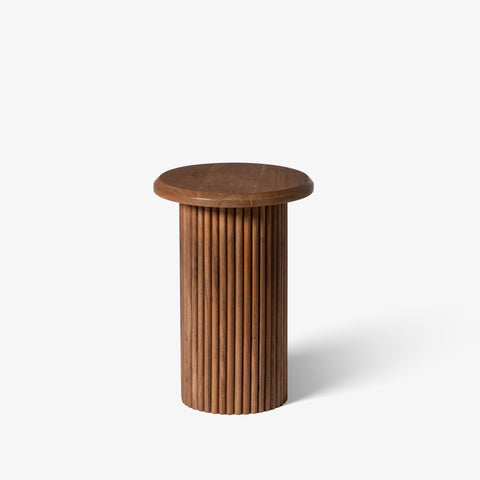 Simple fluted wooden side table isolated on a white background.