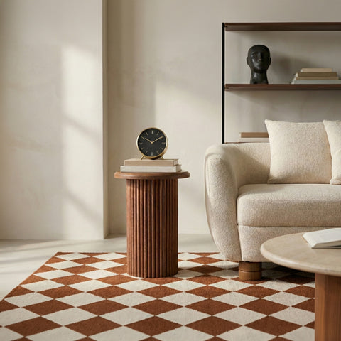 Round wooden fluted side table beside a sofa in a cozy living room.