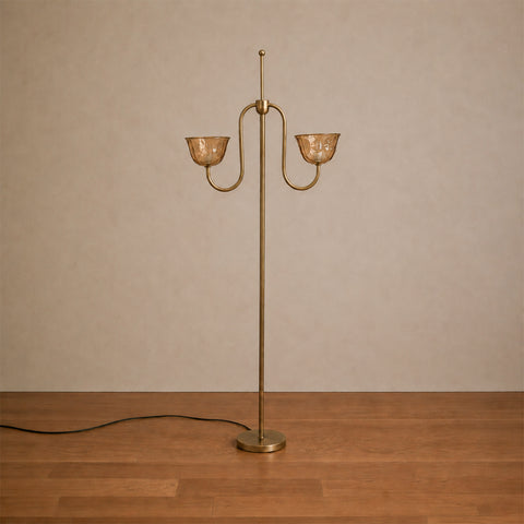 Brass floor lamp with two arched arms and amber shades.