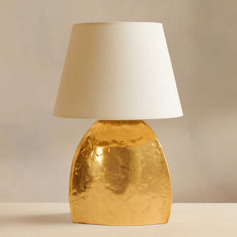 Modern gold table lamp with sculpted metal base and white fabric shade