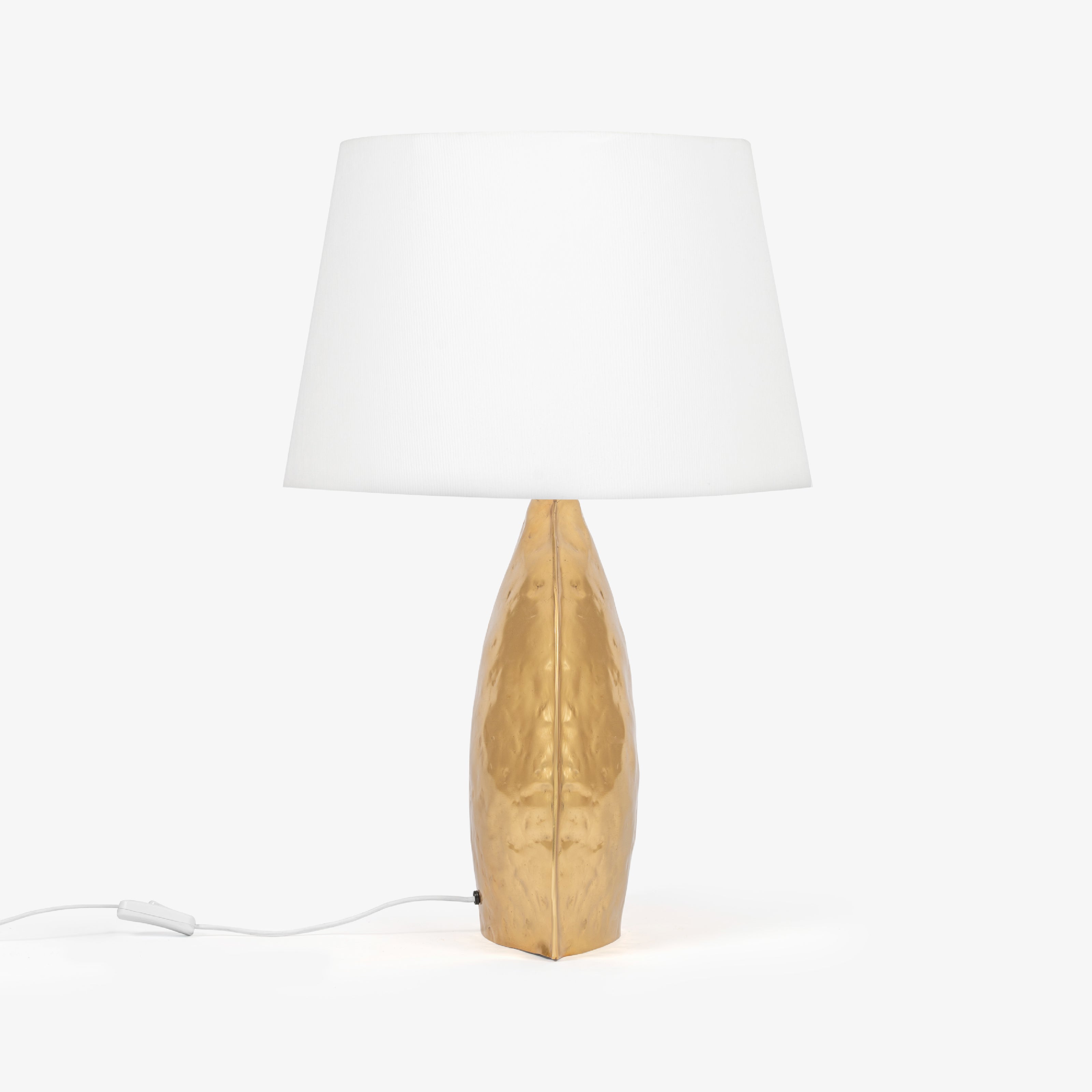 Gold table lamp with sculpted metal base and white fabric shade, modern bedroom table lamp.