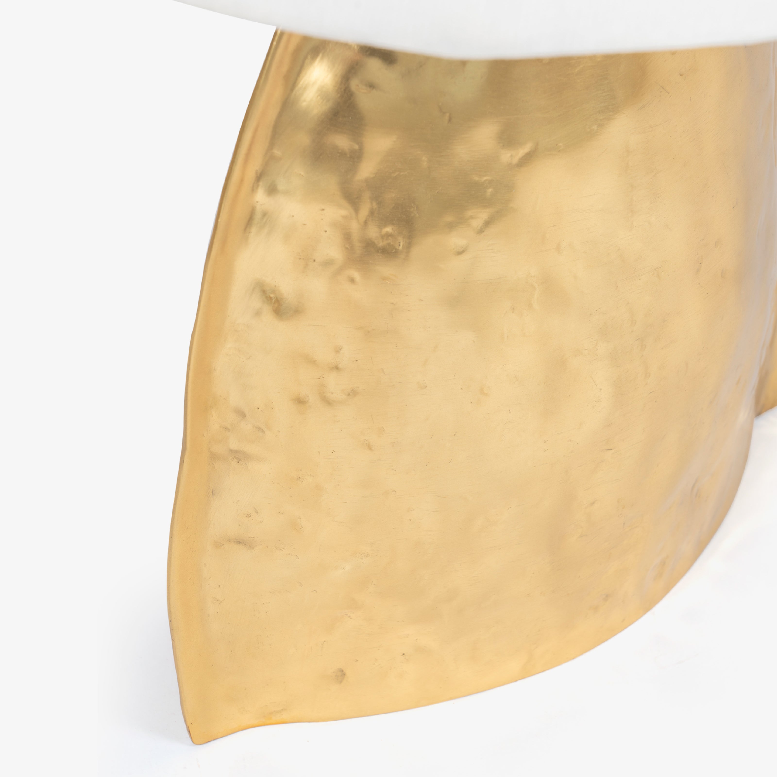 Close-up of hammered gold metal base of a designer table lamp for home decor.