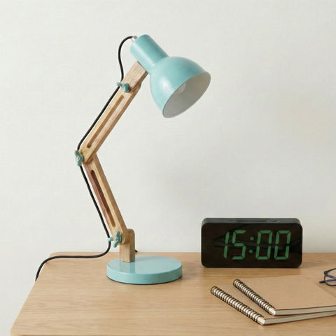 A small adjustable desk lamp with a mint-green shade on a wooden desk.
