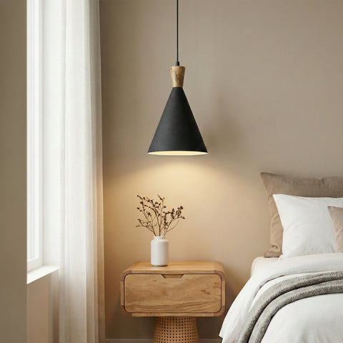 A black cone-shaped pendant light hanging over a minimalist wooden bedside table.