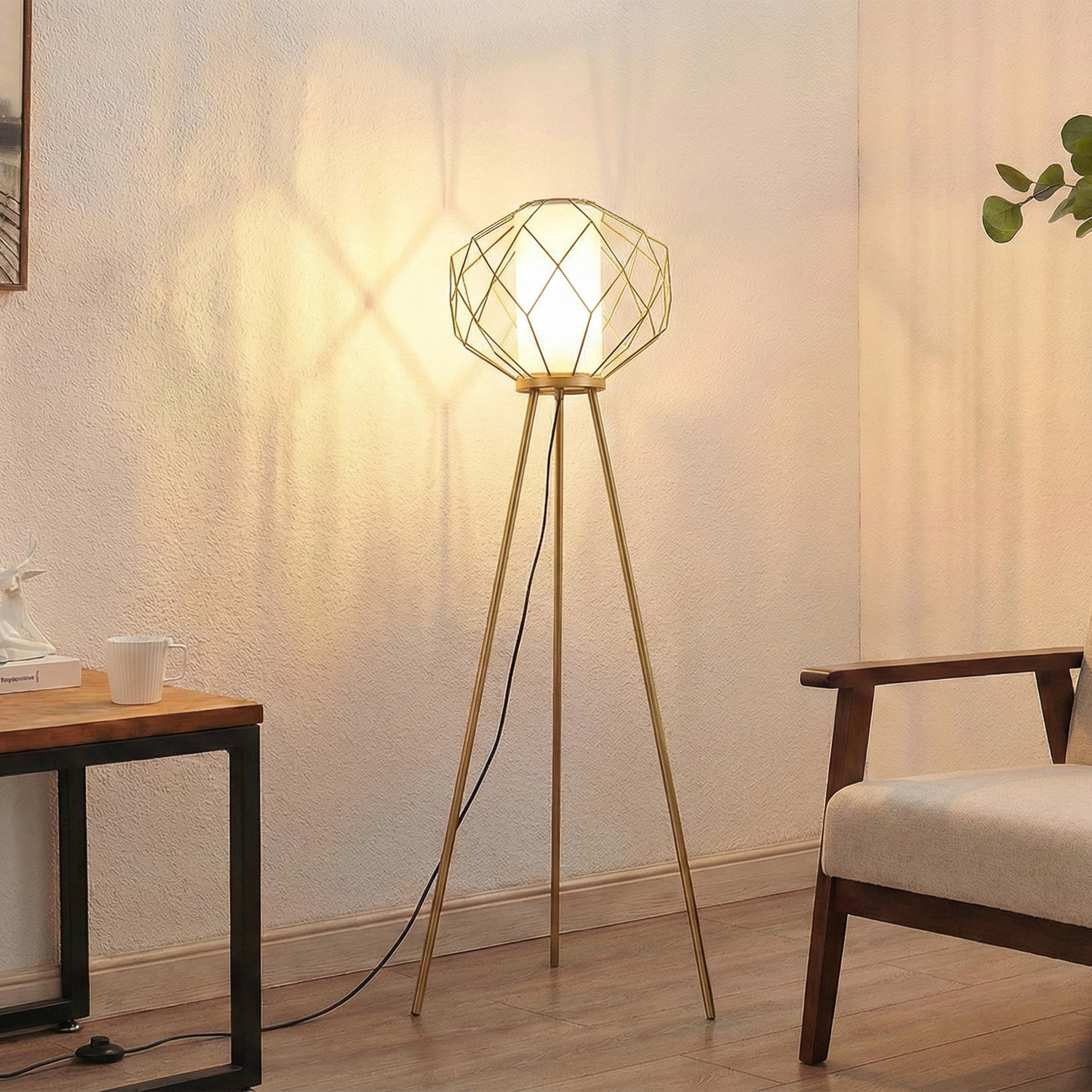 Gold tripod floor lamp with a geometric wire cage and frosted diffuser.