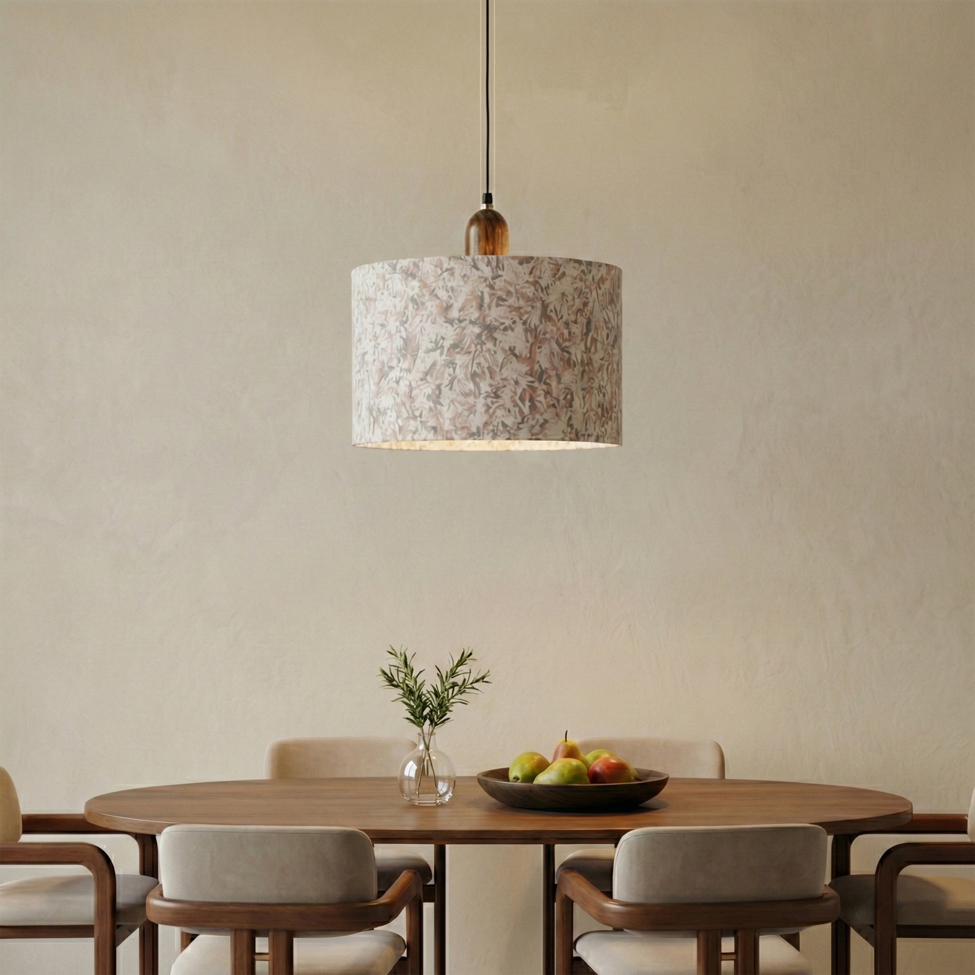 Fabric pendant light above a wooden dining table with neutral chairs.