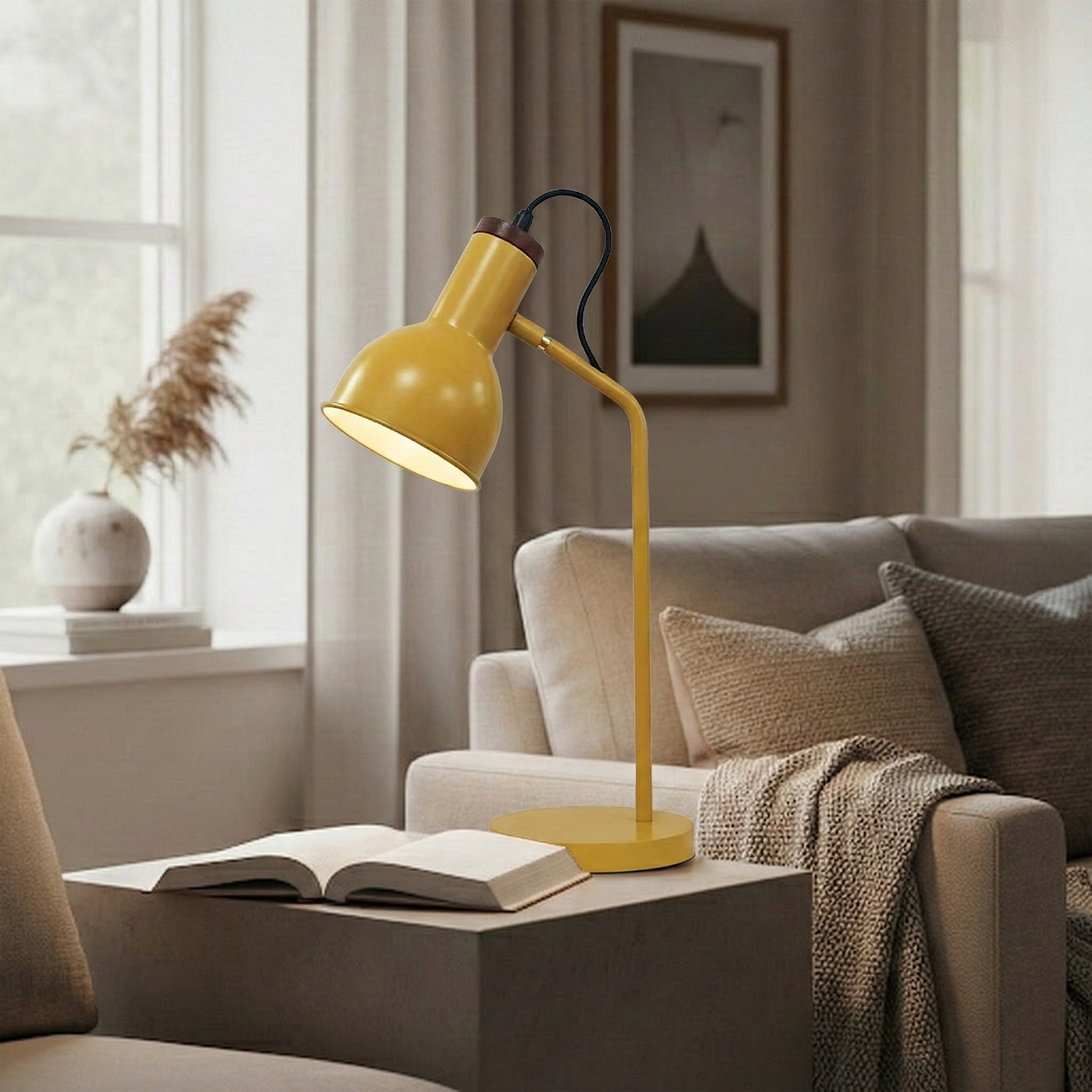 Matte yellow adjustable desk lamp on a side table next to a book.