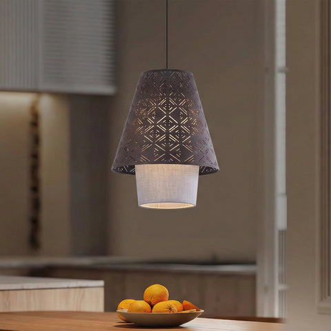 A modern pendant lamp hangs above a wooden table with a bowl of oranges