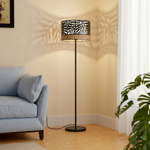 A modern floor lamp with a black palm leaf in a living room