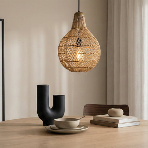 teardrop-shaped woven rattan pendant light hanging over a modern wooden dining table.