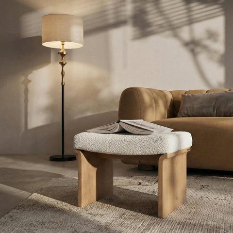 pouf with a book on top, set in a warm living room with a sofa and floor lamp.