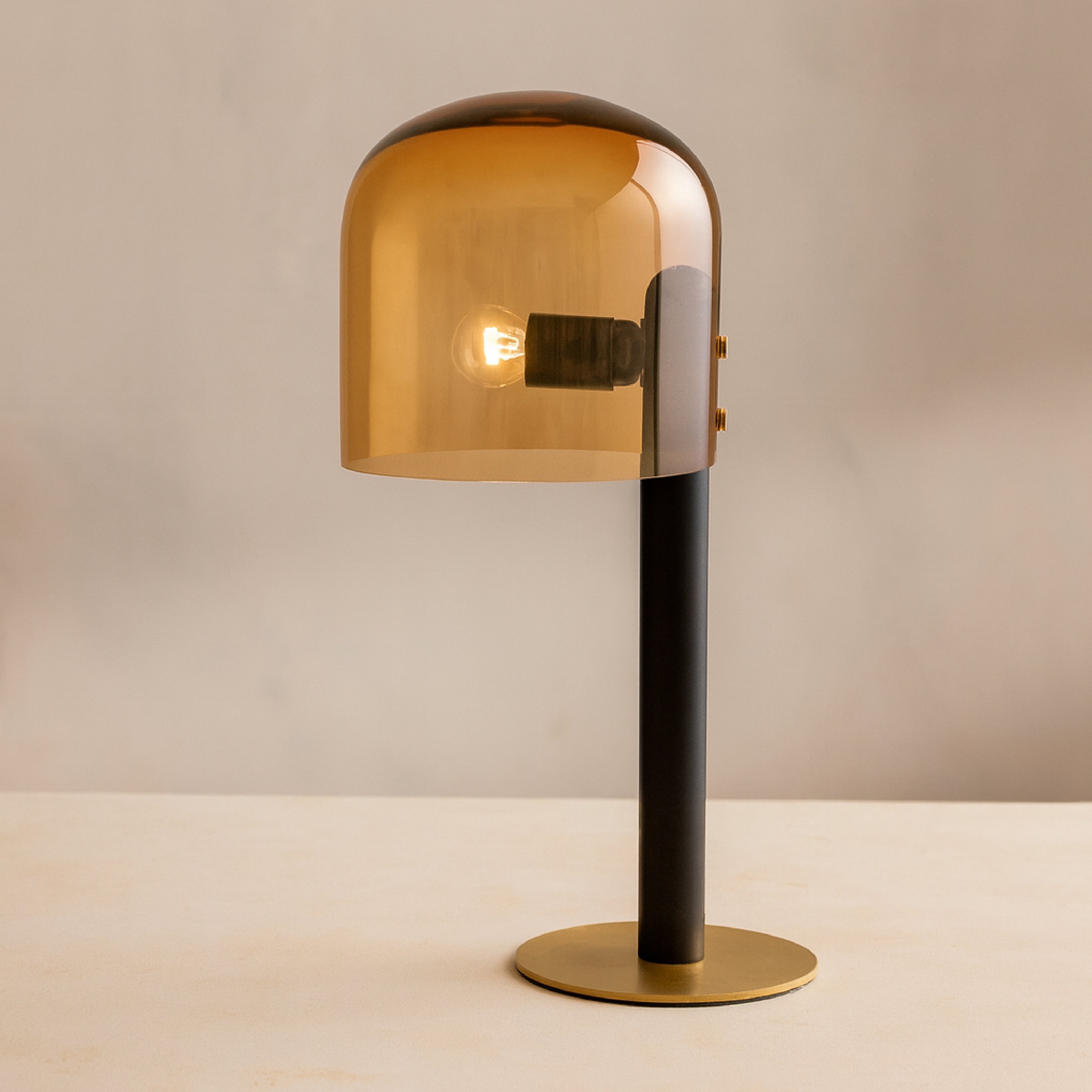 Modern table lamps with a transparent orange shade and a sleek black metal stem.