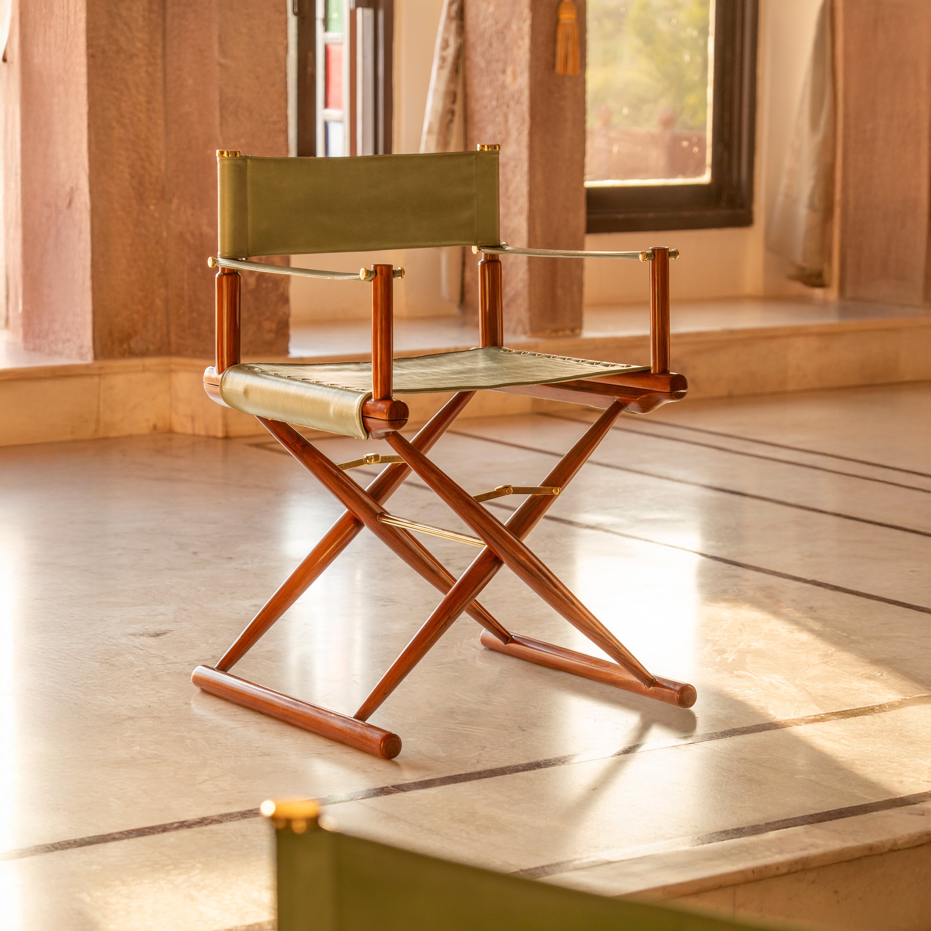Wooden director chair with green fabric in indoor setting
