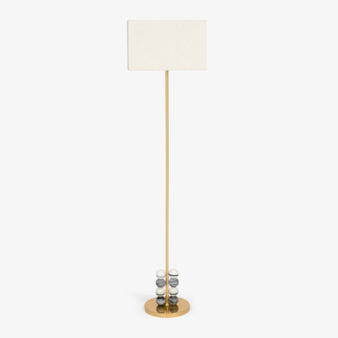 Minimal floor lamp in brass finish with linen shade and sculptural marble base.