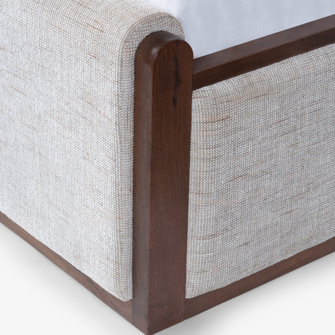 Close-up of upholstered bed corner with wood trim