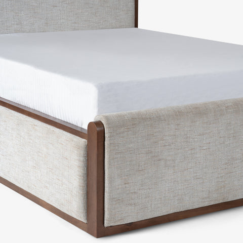 Mattress on beige upholstered bed frame