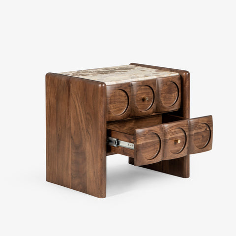 Angled view of carved wood bedside table with drawer open