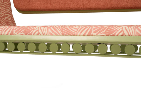 Close-up of the swing's base detailing a row of green circular decorative elements under the seat.