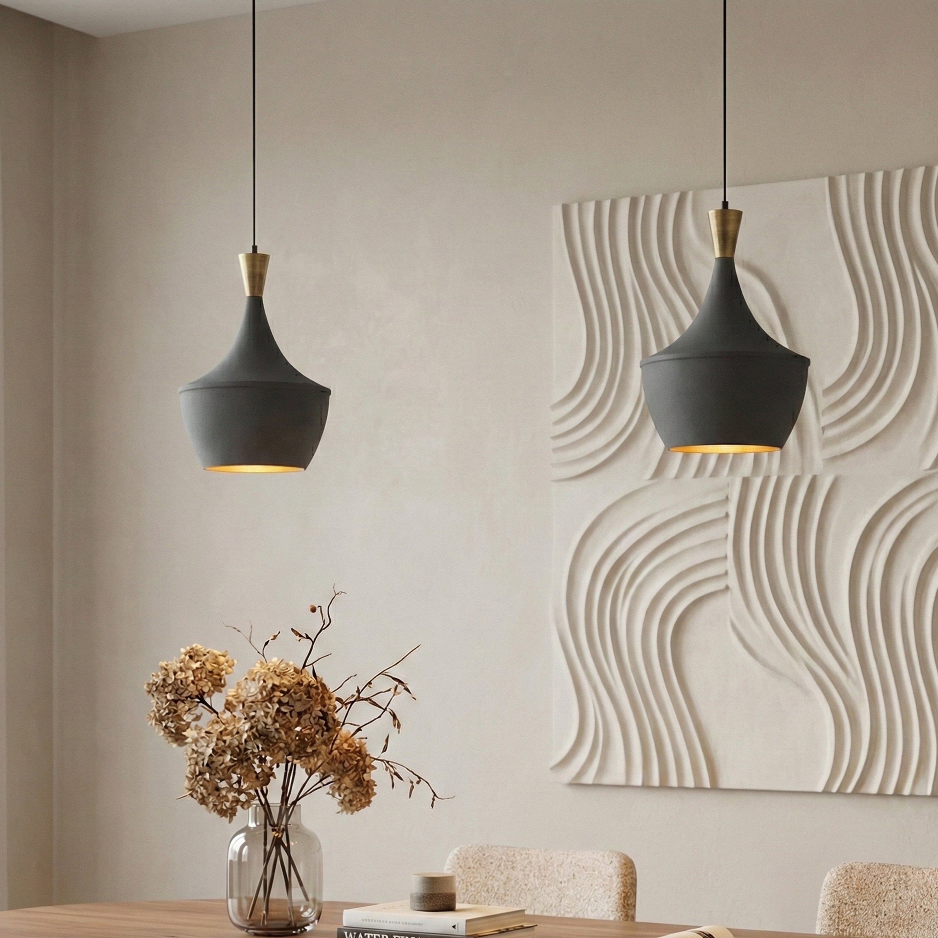 Two modern black pendant lights above a dining table with textured wall art.