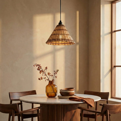 Rattan pendant light casting warm shadows over a round dining table by a window.